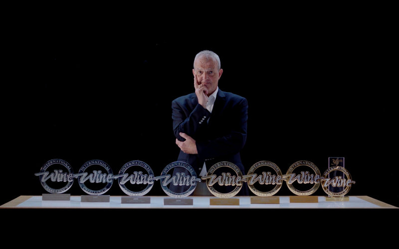 Wine critic presenting HEAVENSAKE sake bottles at an awards or tasting event