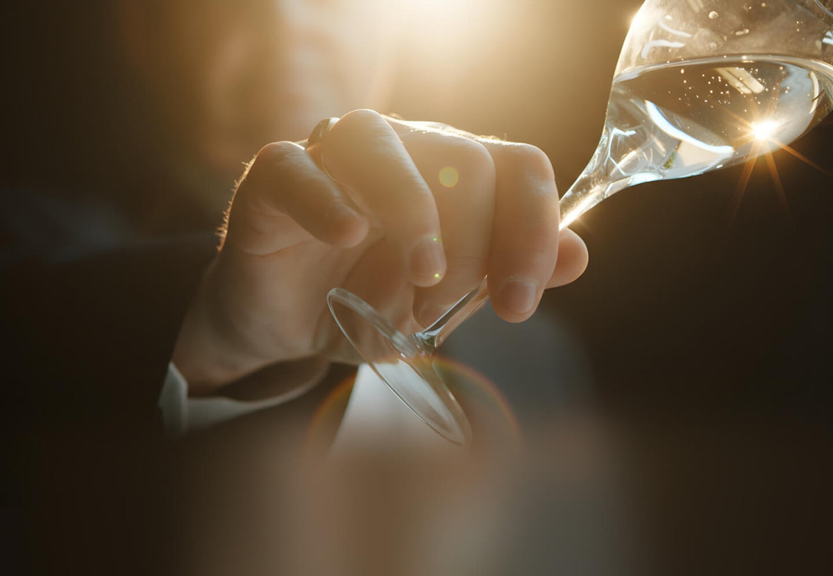 A wine glass of sake held up to the light.